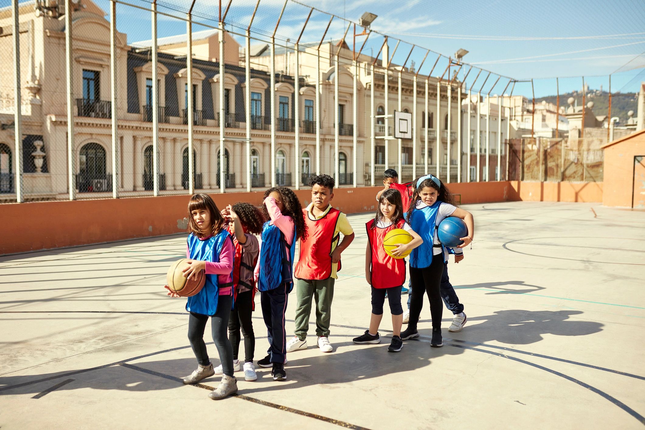 Niños en el patio escolar esperando su turno para jugar