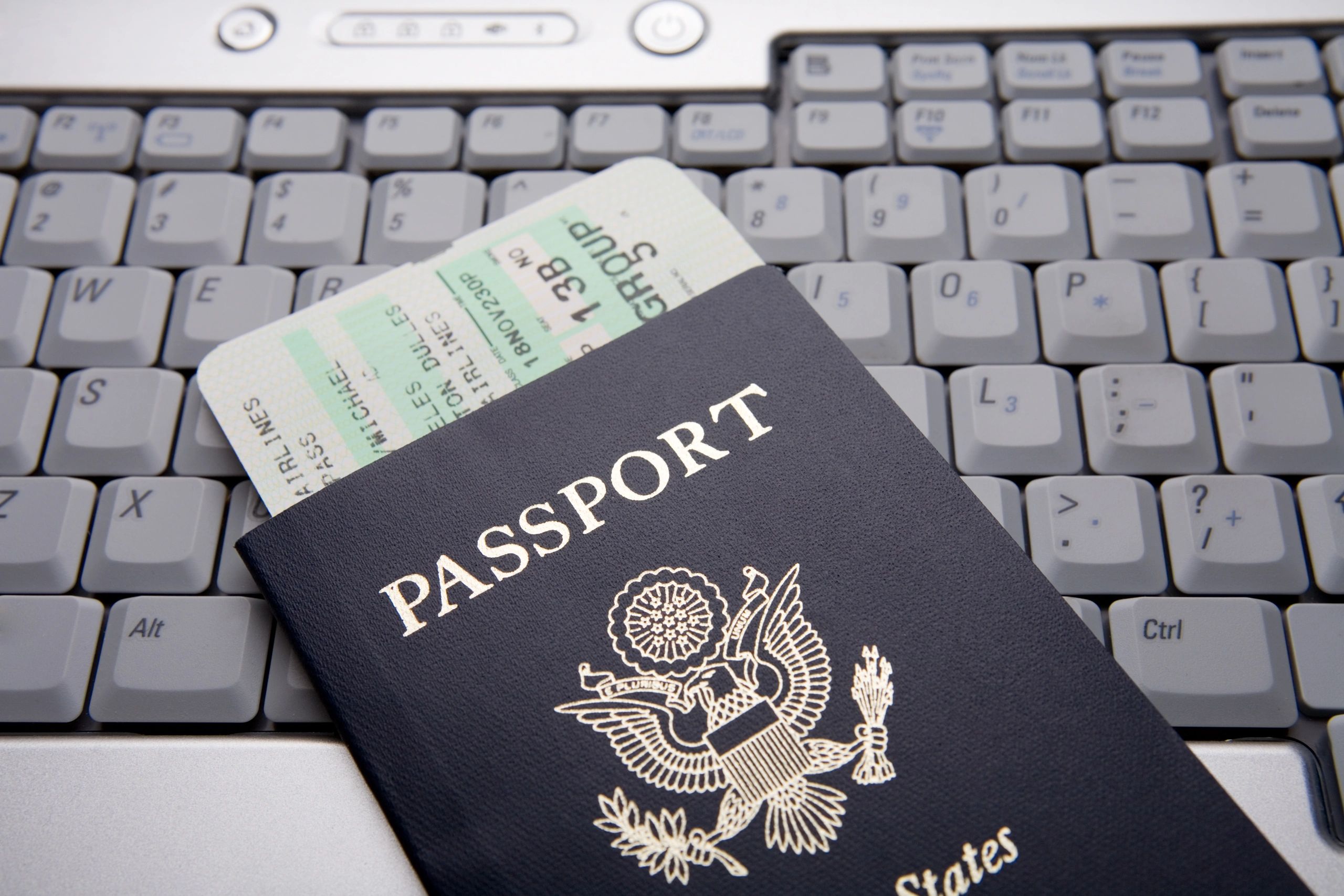 Pasaporte y documentos sobre un portátil