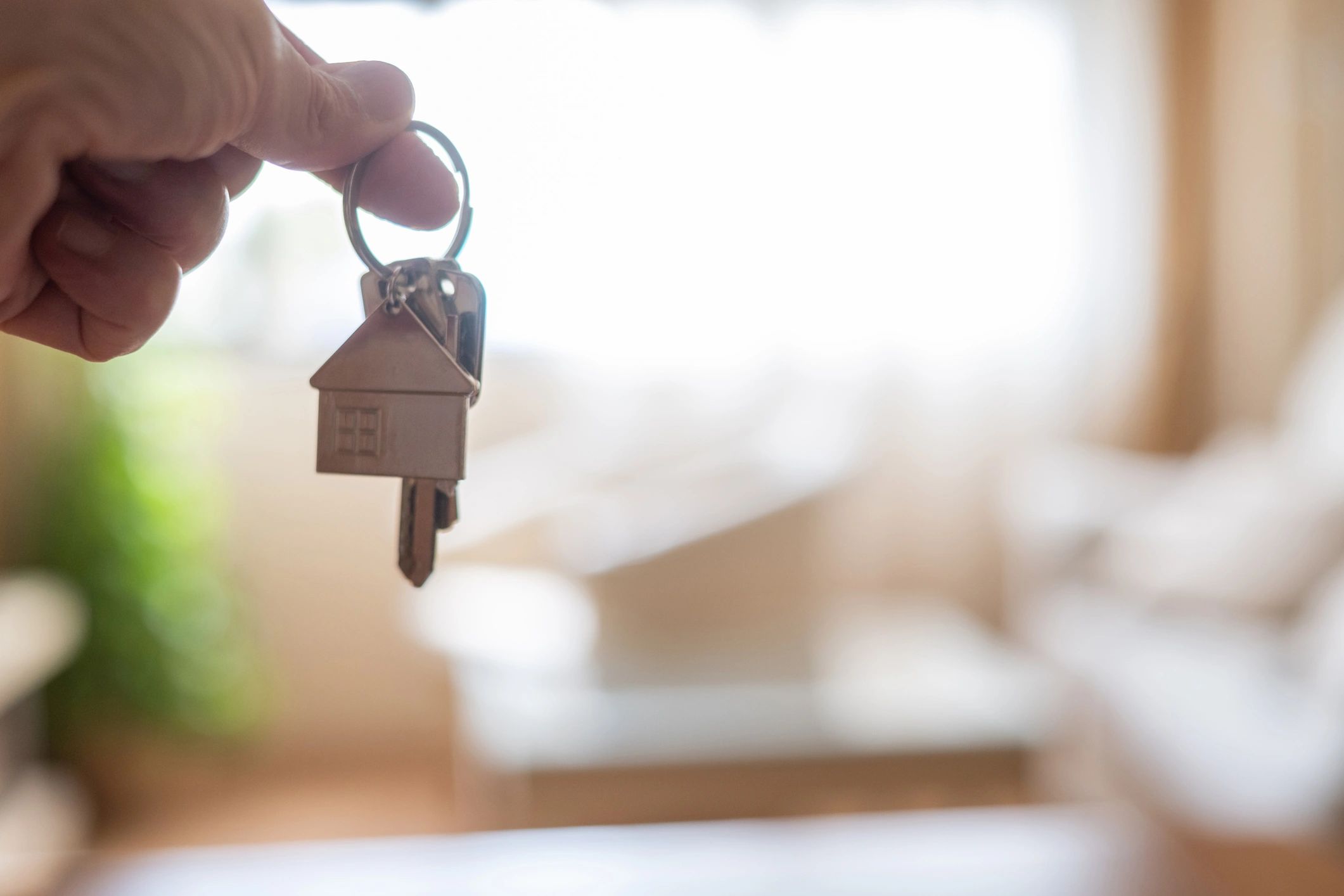 Mano sosteniendo llaves de una vivienda, símbolo de mudanza y alquiler